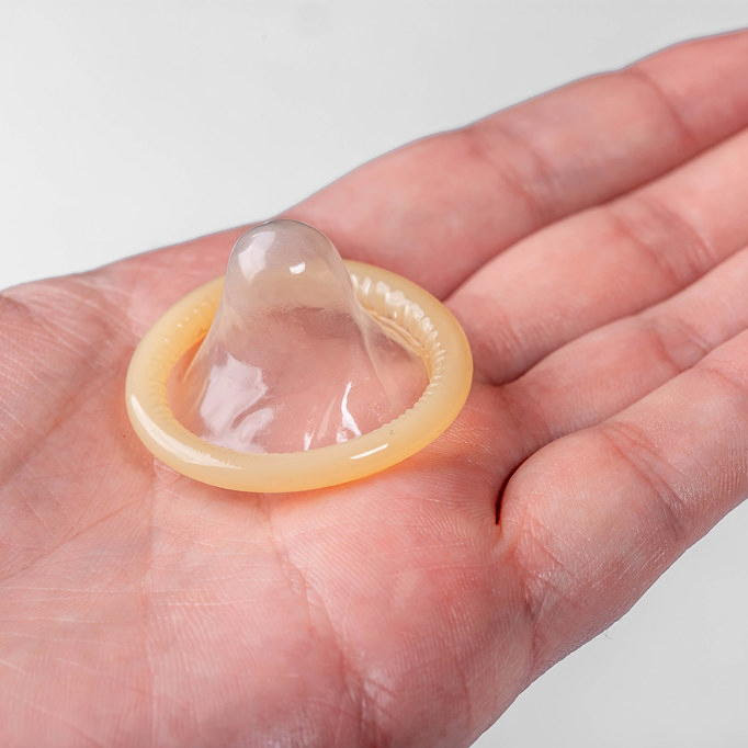 On the hand of a man condom on a white background