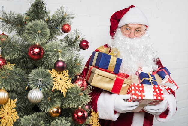Santa with gift boxes hands near decorated christmas tree 23